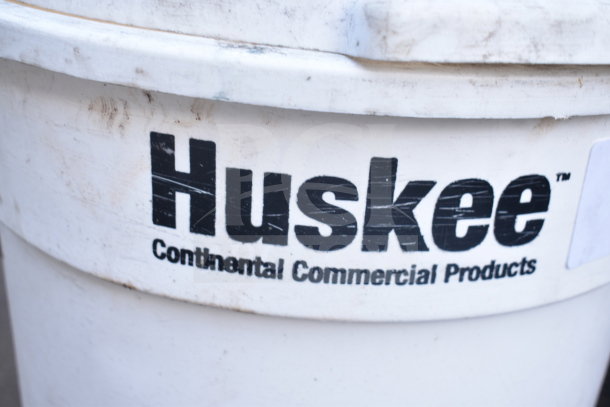 Two white Huskee poly trash cans with lids, Continental Commercial Products, showing wear. Auction offers double bid value.