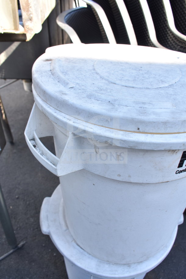 Two white poly trash cans with lids, used condition, featuring side handles. Auction bid multiplier applies.