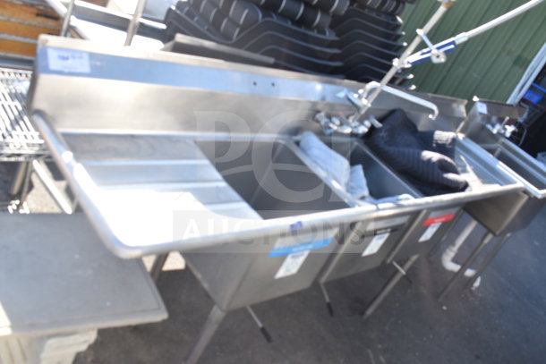 Commercial 3 bay sink with dual drain boards, stainless steel, includes faucet, pre-owned condition, visible labels on basins.
