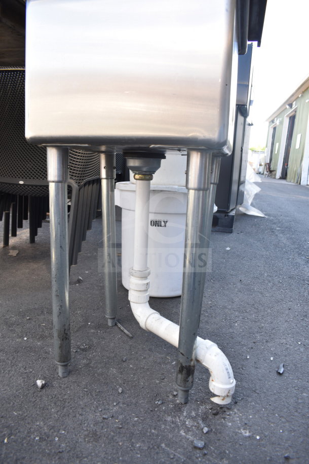 Commercial single bay sink with stainless steel construction and pipe fittings. Used condition with visible dirt on legs.