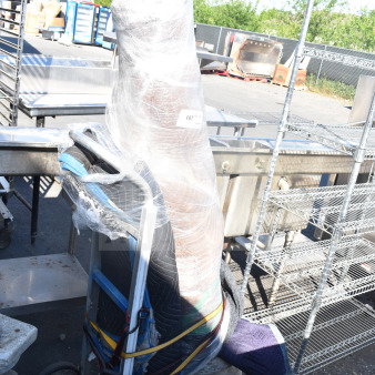 Wrapped statue on a dolly, secured with straps. Appears in good condition. Label visible: "187". Outdoor setting.