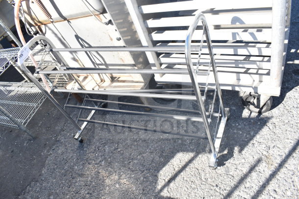 Metal shoe rack with four shelves, chrome finish. Good condition. Tag marked "189." Suitable for organizing footwear.