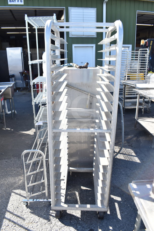 Commercial pan transport rack with multiple shelves on sturdy commercial casters, in good condition for efficient mobility.