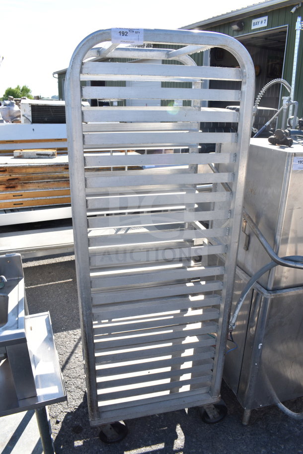 Commercial pan transport rack with multiple shelves, on sturdy commercial casters; features a metallic finish.