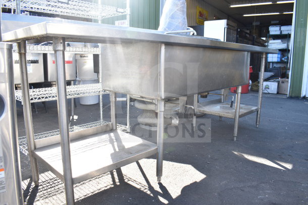 Commercial 2 bay sink with dual drain boards, stainless steel, sturdy legs, and visible plumbing. Ideal for restaurant use.