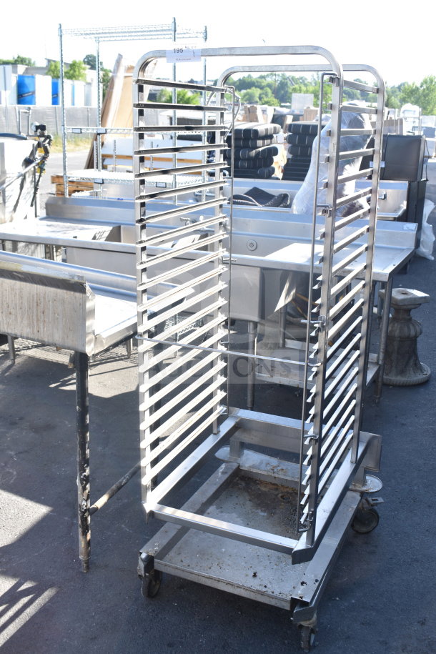 Commercial pan transport rack on casters, compatible with roll-in ovens. Sturdy metal frame, visible wear on wheels.
