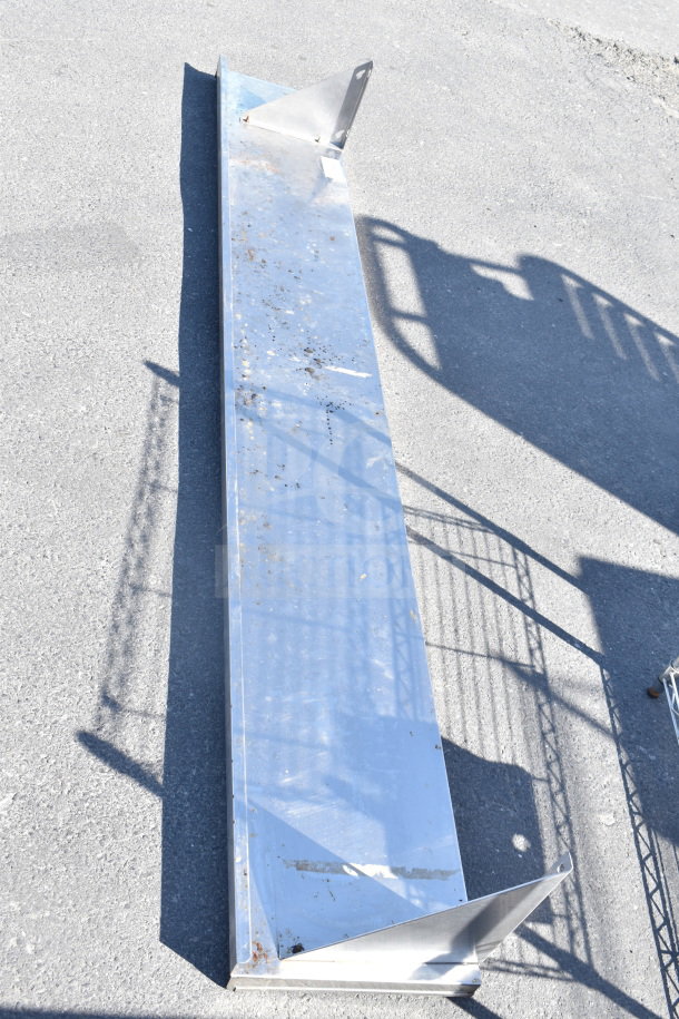 Metal shelf with angular brackets, showing signs of rust and wear. Functional condition, suitable for industrial use.
