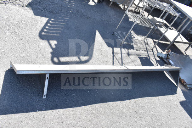 Metal shelf with bracket, in good condition, lying on asphalt. Ideal for storage or display use.
