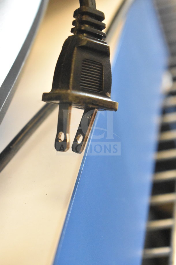 Close-up of a black power plug against a blue and beige background.