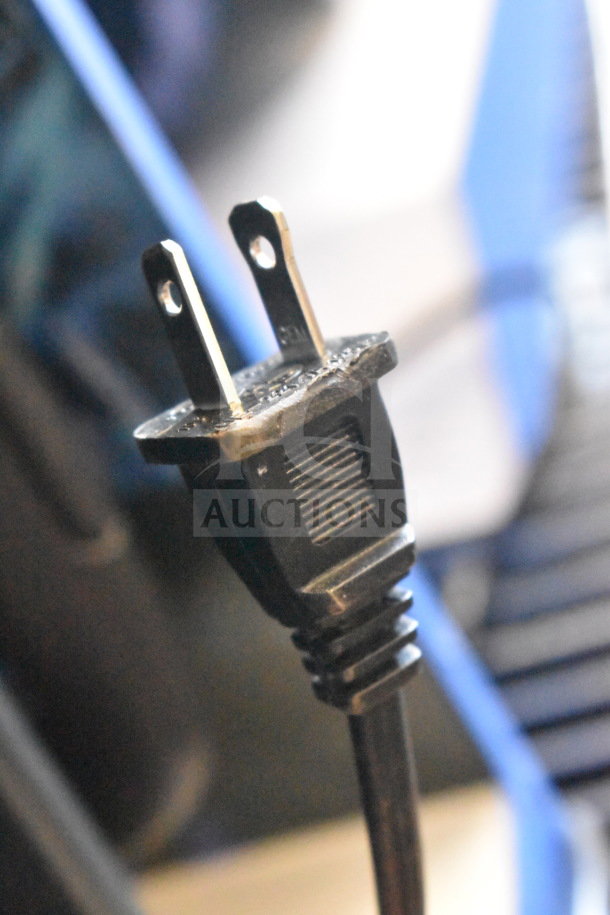 A close-up of a standard black two-prong electrical plug, partially inserted, with textured grip.
