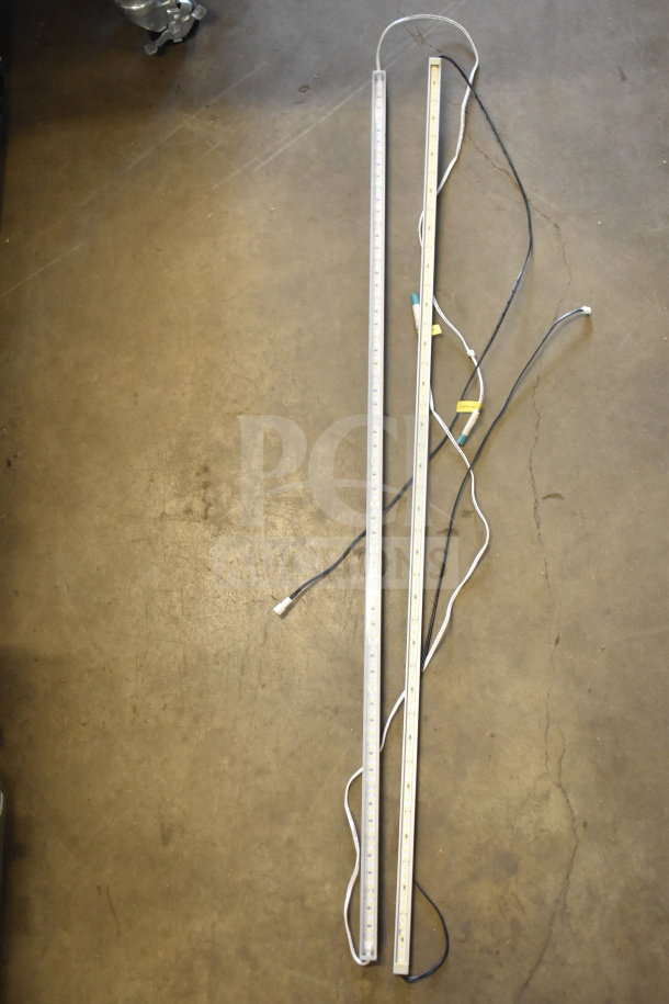Two LED light strips with visible wires on the floor, part of a mixed auction lot including a Bose speaker and Netgear router.