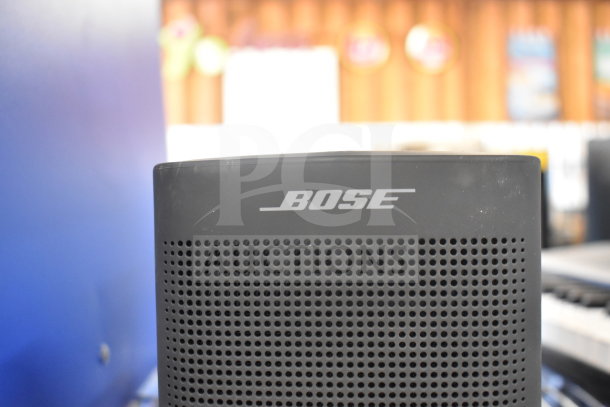 Bose speaker, black, visible logo, excellent condition, part of 8-item auction lot including Netgear router.