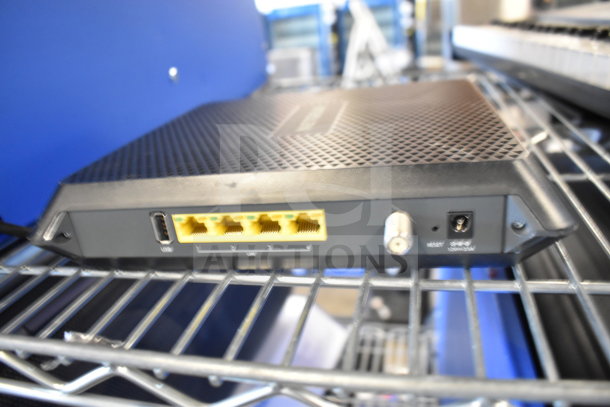 Netgear router with four Ethernet ports, USB input, and power connection, in good condition, on metal shelf.