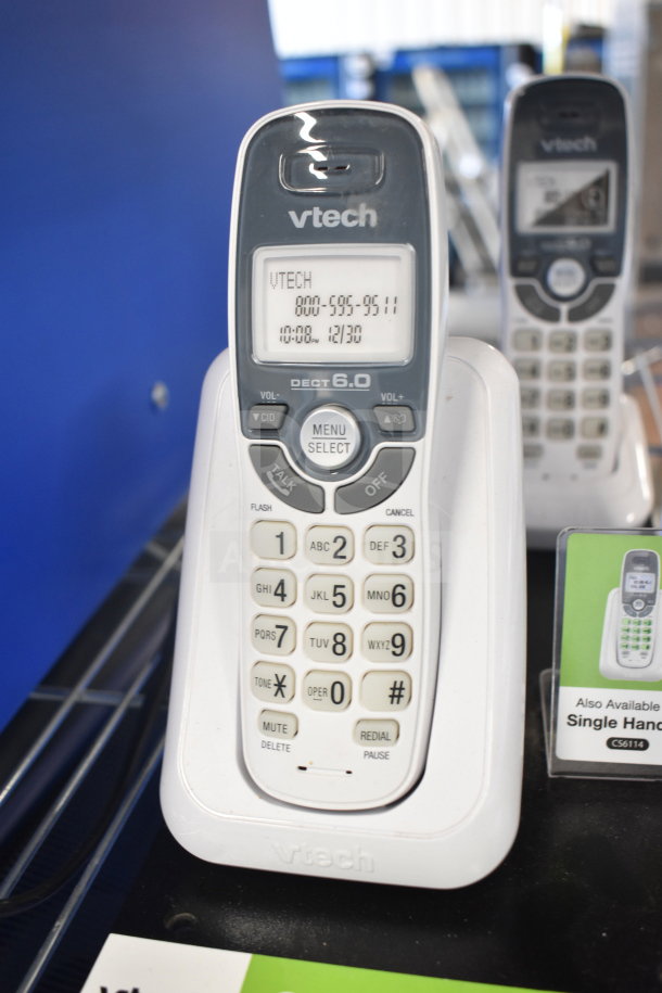 VTech cordless phone with charging base, DECT 6.0, digital display, and keypad. Model info as VTech C5611A visible.