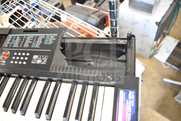 Damaged keyboard with broken panel, visible buttons, and rhythm options. Listed in auction with Bose speaker, Netgear router, Vtech phones.