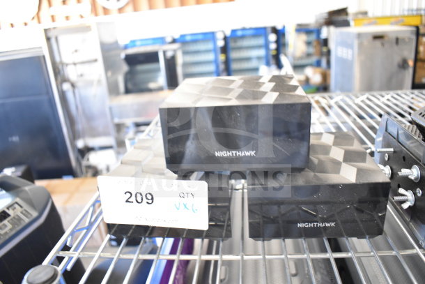 Netgear Nighthawk routers on a metal shelf, labeled "209 QTY VX6" for auction bidding, indicating six items.