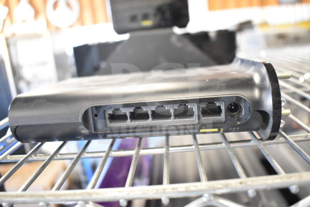 Netgear Nighthawk router featuring multiple Ethernet ports, in used condition, part of auction bundle of six items.