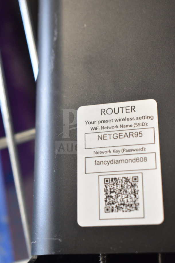 Netgear router showing preset wireless settings label with SSID "NETGEAR95" and password "fancydiamond608."