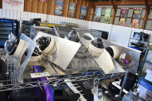 10 dome security cameras mounted on metal plates, in good condition. Includes auction tag number 210.
