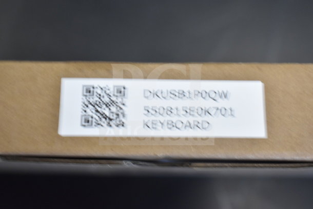 Brown cardboard box with a white label featuring a QR code and the text "DKUSB1PQOW 550815E0K701 KEYBOARD."
