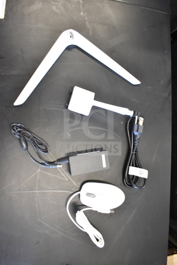 Acer C24B Series PC accessories including white monitor stand, power adapter, mouse, and cables on black surface.