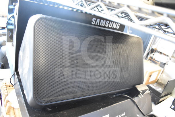 Samsung speaker with mesh grille, includes power cord, in good condition. Auction includes Onn medium party speaker.