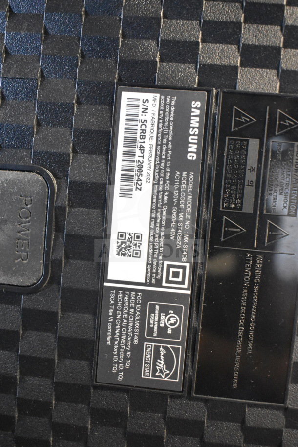 Samsung speaker label with model MX-ST40B, serial S/N: 5CRB14PT209542Z, featuring power button and warning icons.