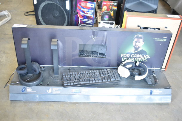 Store display featuring Razer keyboard and headphones. Includes two headphone stands, promotional graphics, and visible wear.