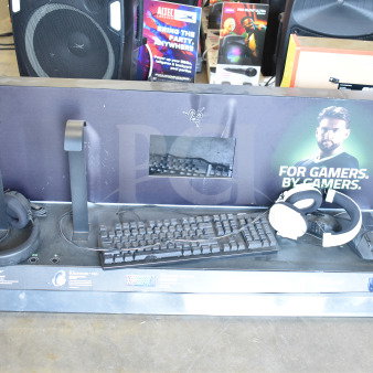 Store display featuring Razer keyboard and headphones. Includes two headphone stands, promotional graphics, and visible wear.