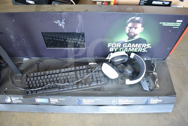 Razer store display with BlackShark V2 Pro headphones and Huntsman keyboard. Used condition, visible logos and promotional graphics.