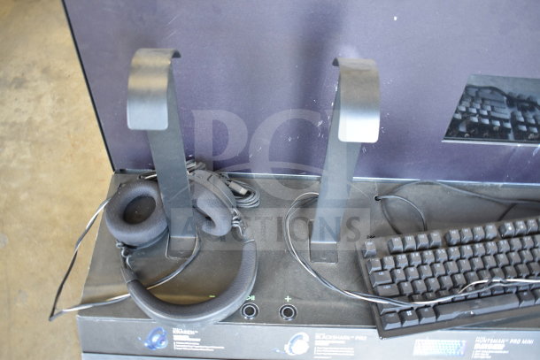 Store display with headphones on stand and keyboard. Features promotional tags for product models. Good condition.