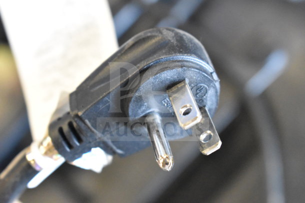 Close-up of a black power plug attached to the Altec Lansing IMT7002 speaker, showing standard prongs.