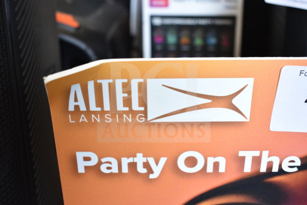 Altec Lansing store display with "Party On The" text, featuring two speakers. Minor wear visible on the corner.