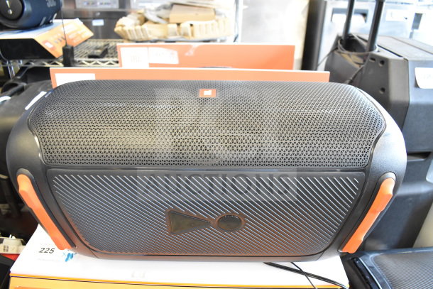 JBL speaker store display, black with orange accents, perforated grille, in good condition, includes branding and labels.