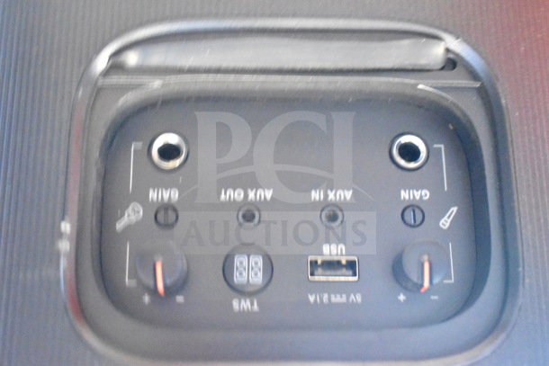Control panel of JBL speaker with AUX in/out, USB port, and gain knobs. Dust present indicates moderate wear.