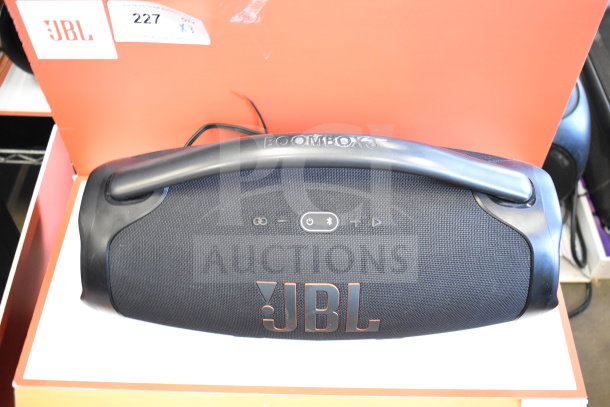 JBL Boombox 3 speaker on store display, black with logo and control buttons visible; excellent condition.