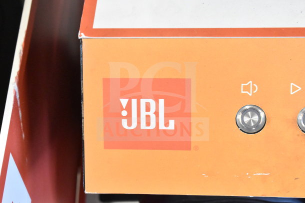 JBL Boombox 3 store display with volume and play/pause buttons, featuring the iconic JBL logo on an orange background.