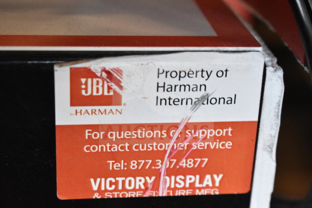 Label on JBL Harman store display indicates "Property of Harman International" and provides customer service contact info.