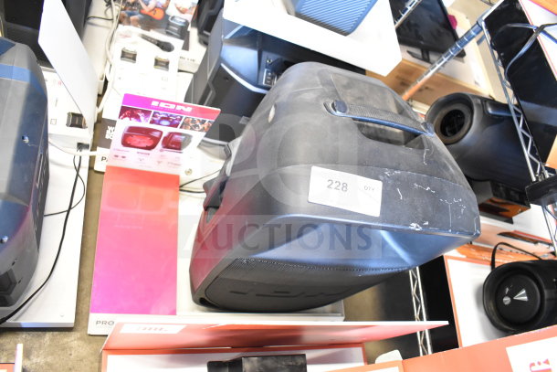Store display featuring Ion Pro Glow 1500 speaker, visible wear, label showing quantity “228,” black with handle.
