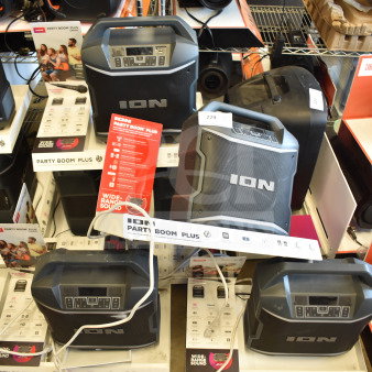 6 Ion Party Boom Plus speakers on display, each in new condition. Featured with control panels, handles, and original packaging.