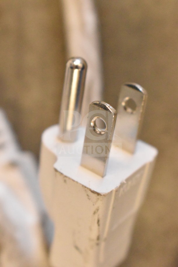 Close-up of a white three-prong plug, part of the Ion Party Boom Plus Speaker display unit.