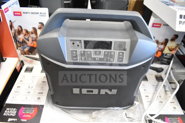 Ion Party Boom Plus speaker on display. Features Bluetooth, mic input, USB charging. Includes product packaging. New condition.