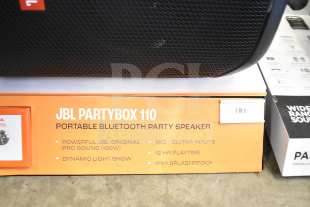 Store display featuring JBL Partybox 110 Portable Bluetooth Speaker, 160W sound, dynamic light show, mic/guitar inputs, 12-hour playtime, IPX4 splashproof.