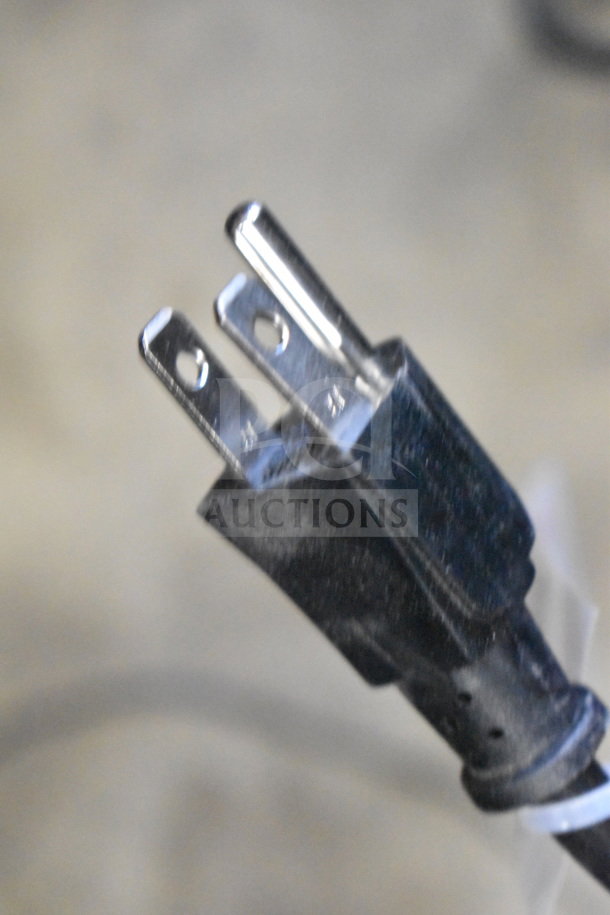 Close-up of a black power plug with two metal prongs, typically used for electronic devices.