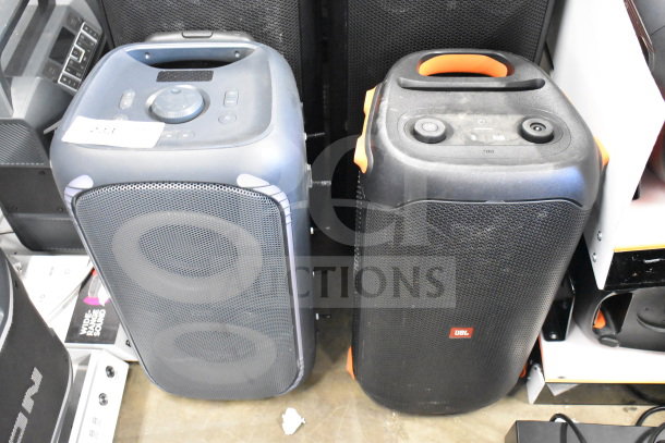 Two JBL speakers shown side-by-side, featuring control panels and carrying handles, in gently used condition.