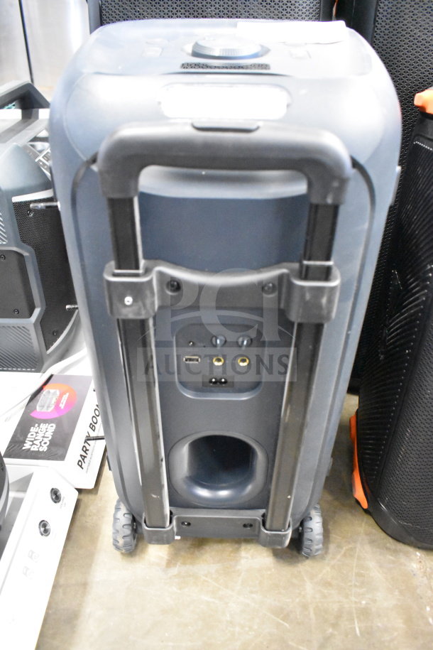 JBL speaker with handle and wheels, featuring ports for connectivity. Good condition. Includes an additional item.
