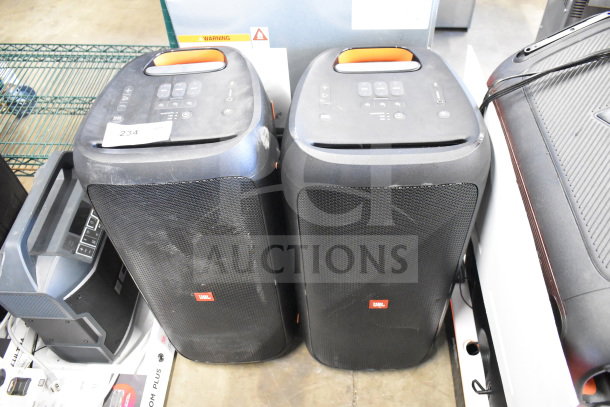 Two JBL Partybox 310 speakers, portable with built-in controls, showing signs of use.