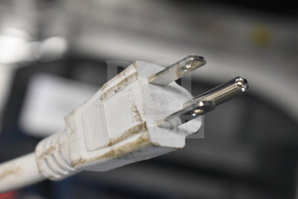 Close-up of a slightly worn white electrical plug with visible markings on the side.