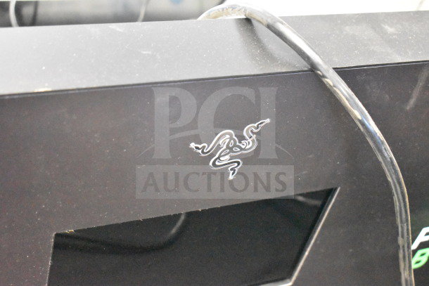 Razer store display with iconic snake logo, black finish, featuring five product slots. Slight surface wear visible.