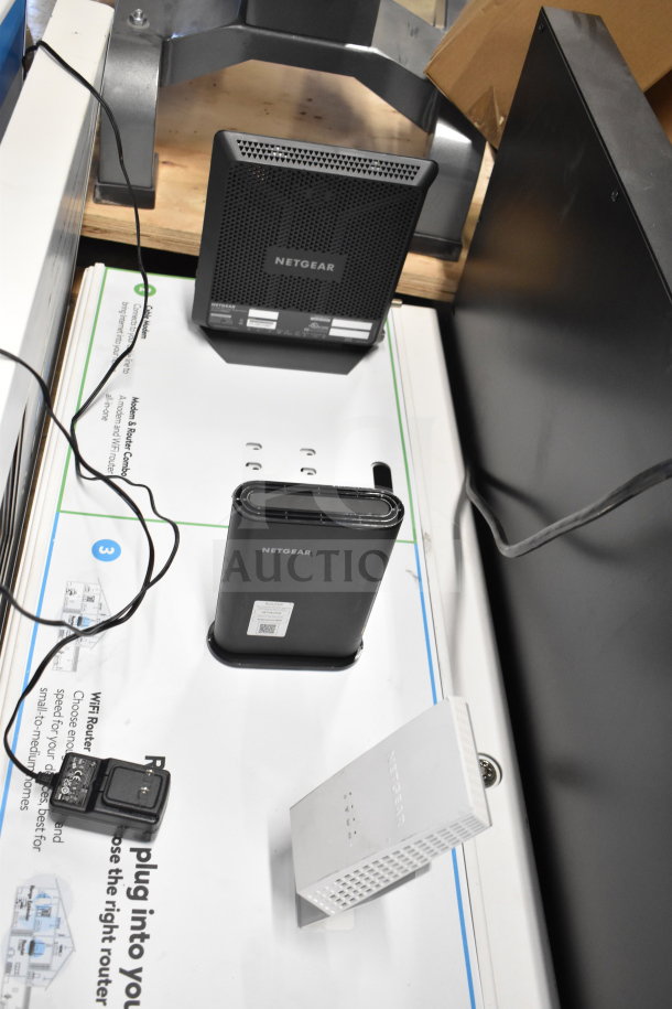 Netgear store display with router and modem models, including tags. Items appear in good condition, ideal for tech setups.
